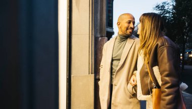 Şık bir çift günü alışveriş yaparak ve şehirde birlikte vakit geçirerek geçirir. Sıkı giyinmişler, bu da serin bir akşam olduğunu gösteriyor..