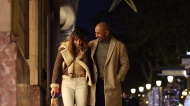 Neşeli bir çift şehir sokaklarında gezer, alışveriş yapar ve dışarıda romantik bir akşam geçirir. Gülümsüyorlar, alışveriş torbalarını tutarken sevgi gösteriyorlar..