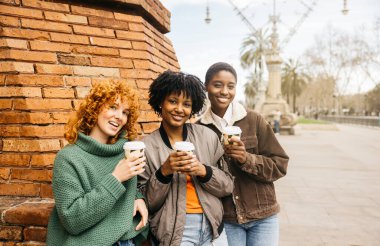Üç farklı bayan turist, Barselona 'daki gezileri sırasında kahve molasının keyfini çıkarıyorlar.