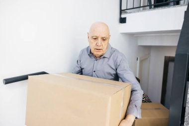 Son sınıf öğrencisi yeni evinde karton kutu taşıyor, taşınıyor ve taşınıyor.