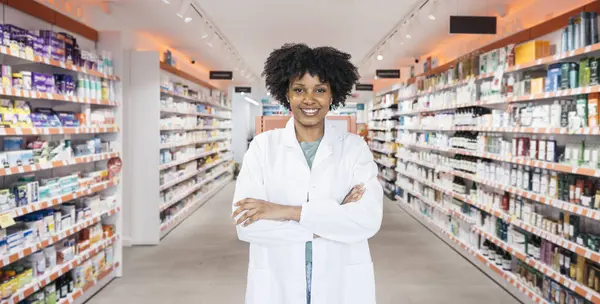 Eczane koridorunda, ilaç ürünleriyle dolu raflarla gülümseyen bir kimyager.