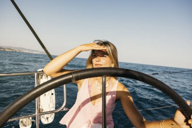 Mutlu bir turist yaz tatilinde güneşli bir günde okyanusta yelken açıyor.