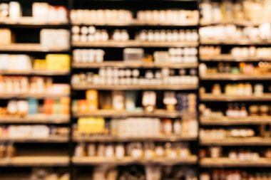 Süpermarketteki stok rafların bulanık görüntüsü çok çeşitli ürünler sunuyor.