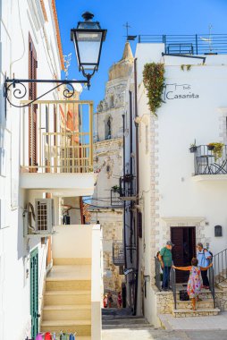 Vieste, İtalya. Bir yaz günü, şehrin tarihi merkezinde Aragonese Kalesi yakınlarında karakteristik dar bir caddenin görüntüsü. Dikey görüntü. 5 Eylül 2022.