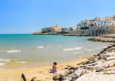 Vieste, İtalya. Lungomare Cristoforo Colombo plajının manzarası. Uzakta San Francesco Kilisesi. 5 Eylül 2022.