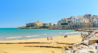 Vieste, İtalya. Lungomare Cristoforo Colombo plajının manzarası. Uzakta San Francesco Kilisesi. 5 Eylül 2022.