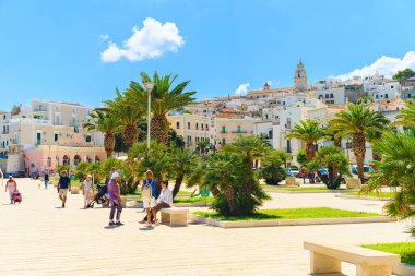 Vieste, İtalya. Kasaba merkezindeki Viale Marinai D 'Italia meydanının manzarası. Palmiye ağaçlarını ve yanından geçen insanları görebilirsin. 5 Eylül 2022.