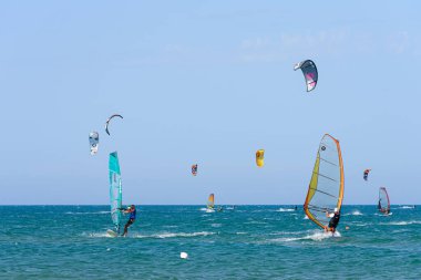 Vieste, Italy. In the sea of Vieste, near the Scialmarino beach, some people practice windsurfing and others practice kitesurfing. September 7, 2022 clipart