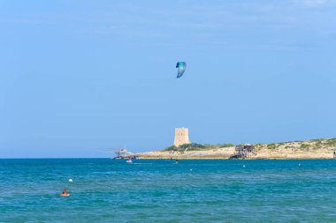 Vieste, İtalya. Scialmarino sahilinin yakınında bir uçurtma. Arka planda Tufara Körfezi ve Porticello Kulesi 'nin trabucco' su var. Vieste sahilinde bir yaz günü. 7 Eylül 2022