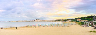 Vieste, İtalya. Akşamları San Lorenzo plajı manzarası. Uzakta, Aragonese Swabian Şatosu ile küçük bir kasaba olan Vieste. Pankart başlığı. 4 Eylül 2022.