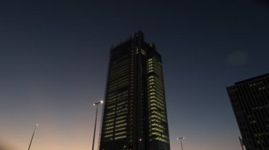 Turin, Italy. Bottom-up view of the skyscraper of the Intesa-San Paolo finance company in Corso England in the evening, while traffic proceeds at the traffic lights. 2022-12-06.