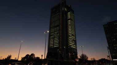 Turin, Italy. Evening view of the skyscraper of the financial company Intesa-San Paolo at the Porta Susa station in Corso Inghilterra, while the lift descends and the traffic proceeds. 2022-12-06.