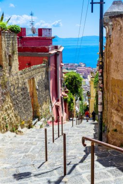 Naples, Italy. View of a glimpse of the Gulf of Naples through the characteristic houses of the Petraio Steps. Vertical image. August 24, 2022.