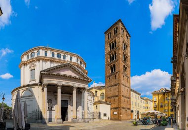 Torino, İtalya. Piazza della Consolata 'dan, Basilica' dan ve Consolata 'nın Mabedi' nden klasik stil portico ile görüntülenir. Sant 'Andrea' nın çan kulesinin ortasında. 2023-05-04.