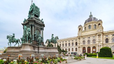 Viyana, Avusturya. Maria-Theresien-Platz 'da, Sanat Tarihi Müzesi cephesi. Önde İmparatoriçe Maria Theresa 'ya adanmış anıt, bahçeler ve çiçekler. 2023-08-03.