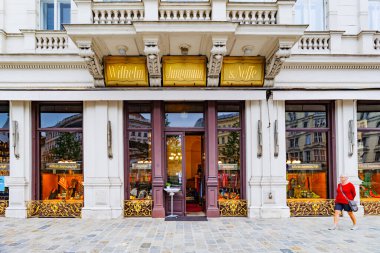 Viyana, Avusturya. Albertinaplatz 'da, kumaş ve giysi satan tarihi bir dükkanın ön cephesi ve pencereleri. 2023-03-08.