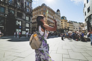 Viyana, Avusturya. Stock-im-Eisen-Platz ve Graben caddesinin manzarası. Profilde genç bir bayan turist görülüyor. Telefonuyla fotoğraf çekmeye çalışıyor. 2023-08-02.