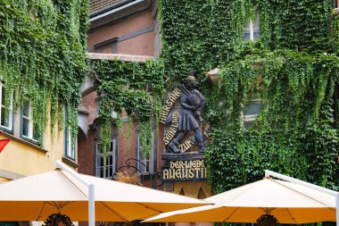 Viyana, Avusturya. Antik ahşap heykel, şimdi bir restoran tabelası, Griechengasse Caddesi 'ndeki bir binanın duvarında karakteristik ve tipik bir Viyana figürü olan Markus Augustin' i gösteriyor. 2023-08-02.