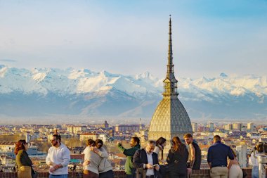 Torino, İtalya. Köstebek Antonelliana Kubbesi ve Cappuccini Tepesi 'nden şehir merkezindeki binalarda bir sürü insan ve turist var. Arka planda Alpler 'in karla kaplı dağları var. 2024-03-12.