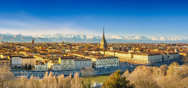 Torino, İtalya. Şehrin yukarıdan görünüşü Köstebek Antonelliana 'nın Kubbesi ve merkezde Cappuccini tepesinden binalar. Arka planda Alpler 'in karla kaplı dağları var. 2024-03-12.