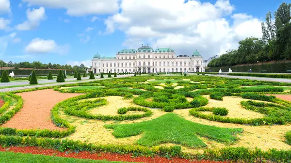 stock image Vienna, Austria. View of the splendid gardens and facade of the Belvedere Palace. In the foreground, the flowerbeds with decorative motifs. 2023-08-04.