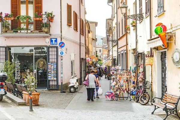 stock image Bolsena, Italy. View of Corso della Repubblica from Piazza Matteotti. A white Piaggio Vespa parked near a tobacconist. Some people are shopping. 2024-06-21.