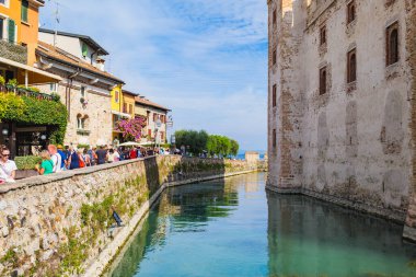 Sirmione, İtalya. Scaligero Kalesi 'nin hendeğinin manzarası. Birçok turist tarihi merkezin sokaklarını dolduruyor. Roma 'nın solunda. 2024-09-22.