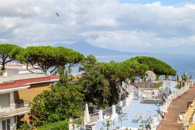 Napoli, İtalya. Napoli Körfezi ve Via Orazio, Posillipo 'dan Vezüv Dağı' nın panoramik manzarası: Çam ağaçları, çatılar ve şehre bakan güneşli bir teras. 2025-07-28.