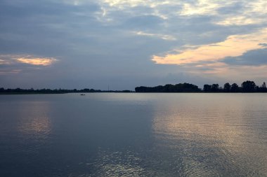 Gün batımında bulutlu bir günde göl