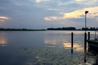 Gün batımında bir gölde lambayla iskele.