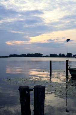 Gün batımında bir gölde lambayla iskele.