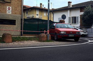 Kırmızı Volkswagen Passat caddeler arasında park halinde.