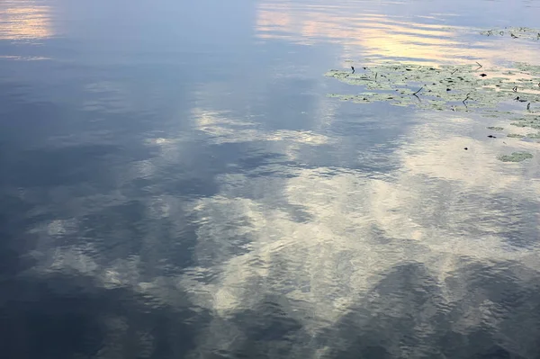 Stock image Cloudy sky at sunset casted in the water