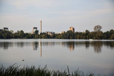 Göldeki sürat teknesi ve uzaklardan görünen bir orman.