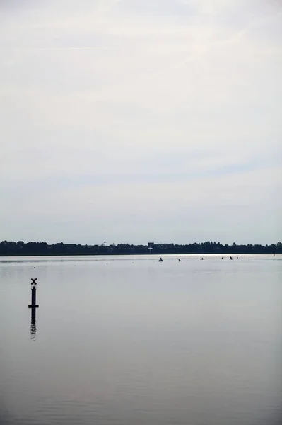 stock image Lake with a pole in the distance on a cloudy day