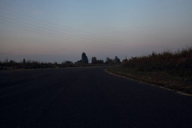 Karanlık çöktüğünde terkedilmiş bir sanayi bölgesinde boş bir yol.