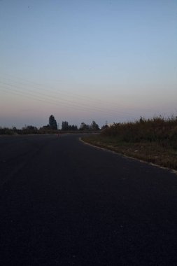 Karanlık çöktüğünde terkedilmiş bir sanayi bölgesinde boş bir yol.