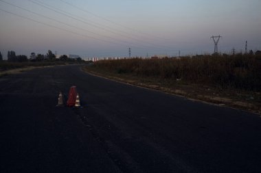 Karanlık çöktüğünde terkedilmiş bir sanayi bölgesinde boş bir yol.