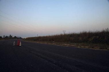 Karanlık çöktüğünde terkedilmiş bir sanayi bölgesinde boş bir yol.