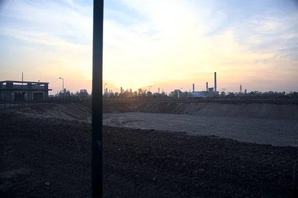 夕阳西下光秃秃的田野外地平线上的工业园区 — 图库照片
