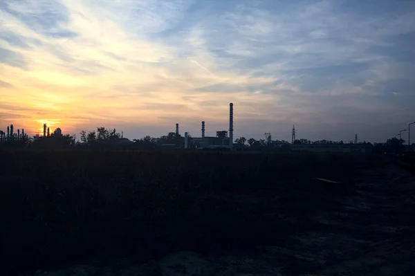 Gün Batımında Çıplak Bir Arazinin Ötesinde Ufukta Sanayi Tesisi Görünüyor — Stok fotoğraf