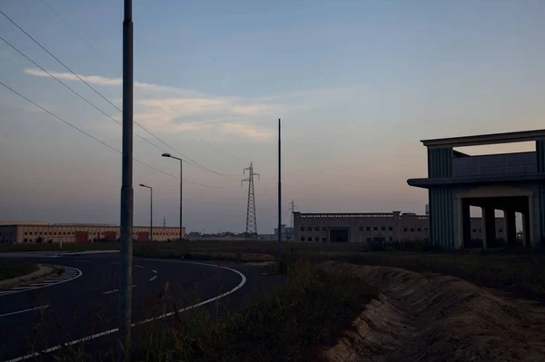 日落时分 在一个工业园区的转盘旁 废弃的仓库和挂塔 — 图库照片