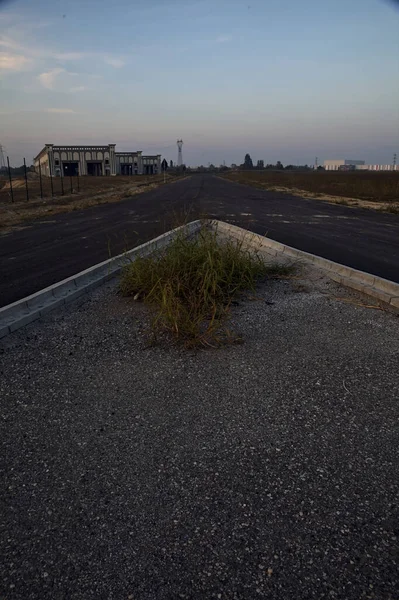 Fork in an empty road in an industrial complex at sunset