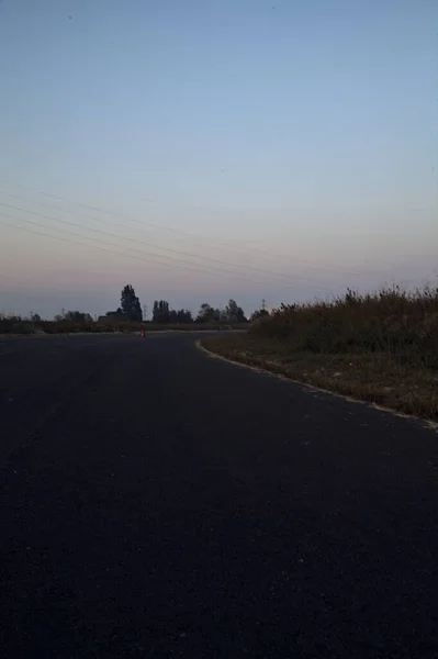 黄昏时分在一个废弃的工业园区里的一条空旷的道路 — 图库照片