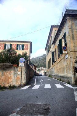 Bulutlu bir günde bir duvarın yanındaki tepenin yukarısında dar bir sokak.