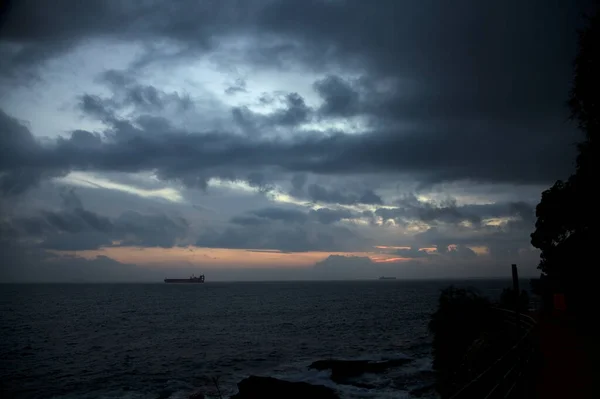 stock image Sea on a cloudy day at dusk with a cargo ship on the horizon