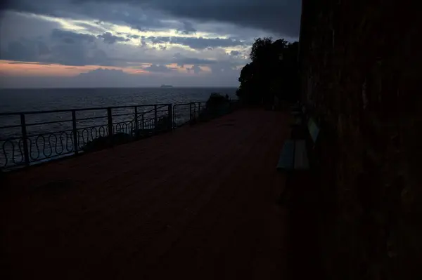 stock image Benches on a promenade by the sea on a cloudy day at dusk