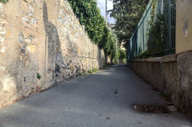 Dar sokaklar taş bir duvarla çevrili ve her iki tarafında bitkiler olan çitlerle çevrili.