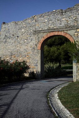 Yol parktaki eski bir sınır duvarının kemerinden geçiyor.