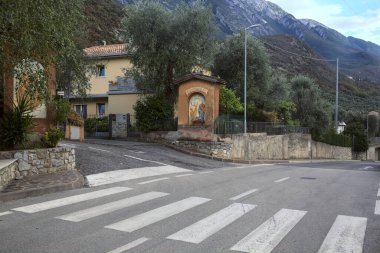 Kenarında küçük bir şapelle kırsal bir yoldan geçiyor.